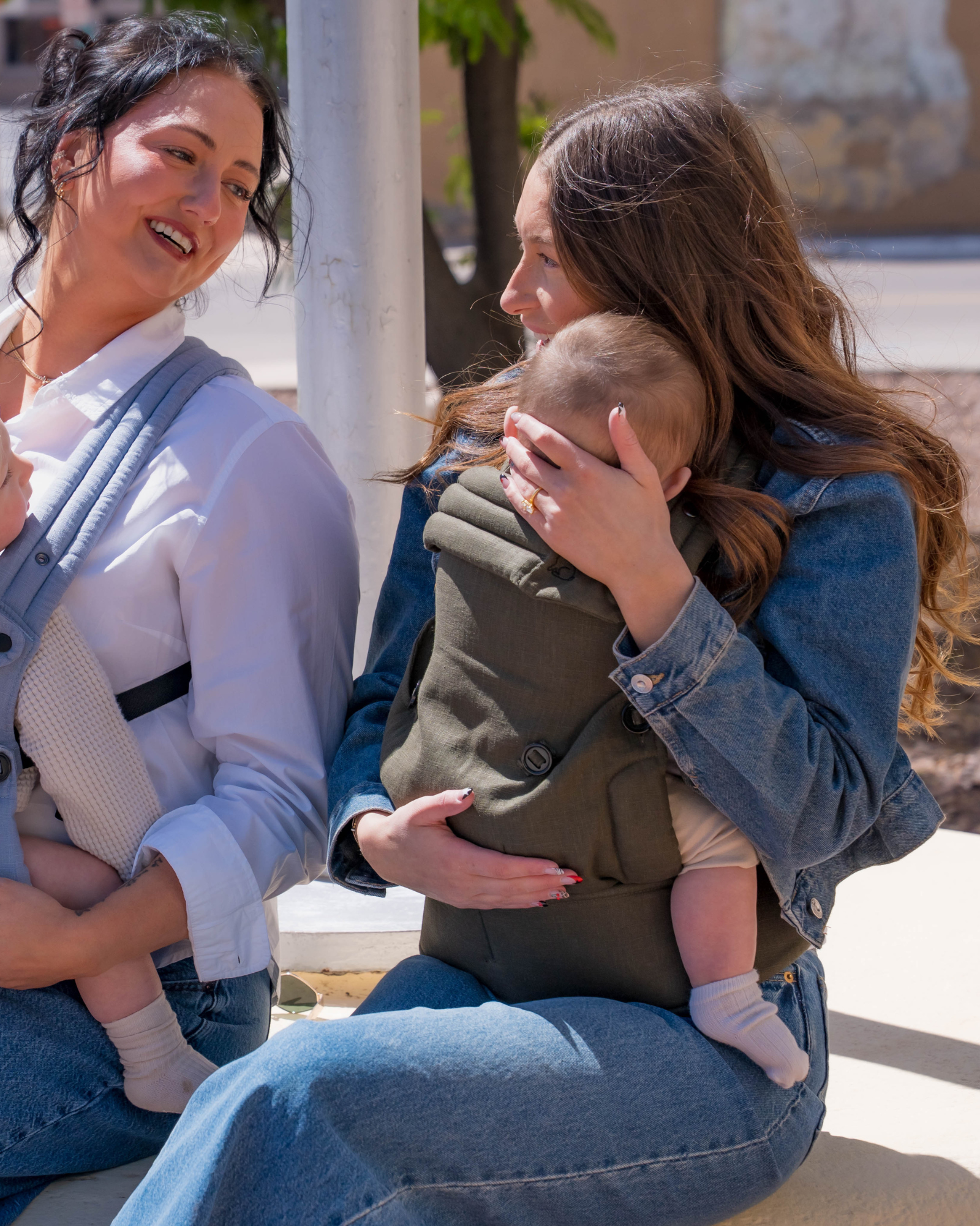Mom wearing ergonomic olive green baby carrier with baby outdoors