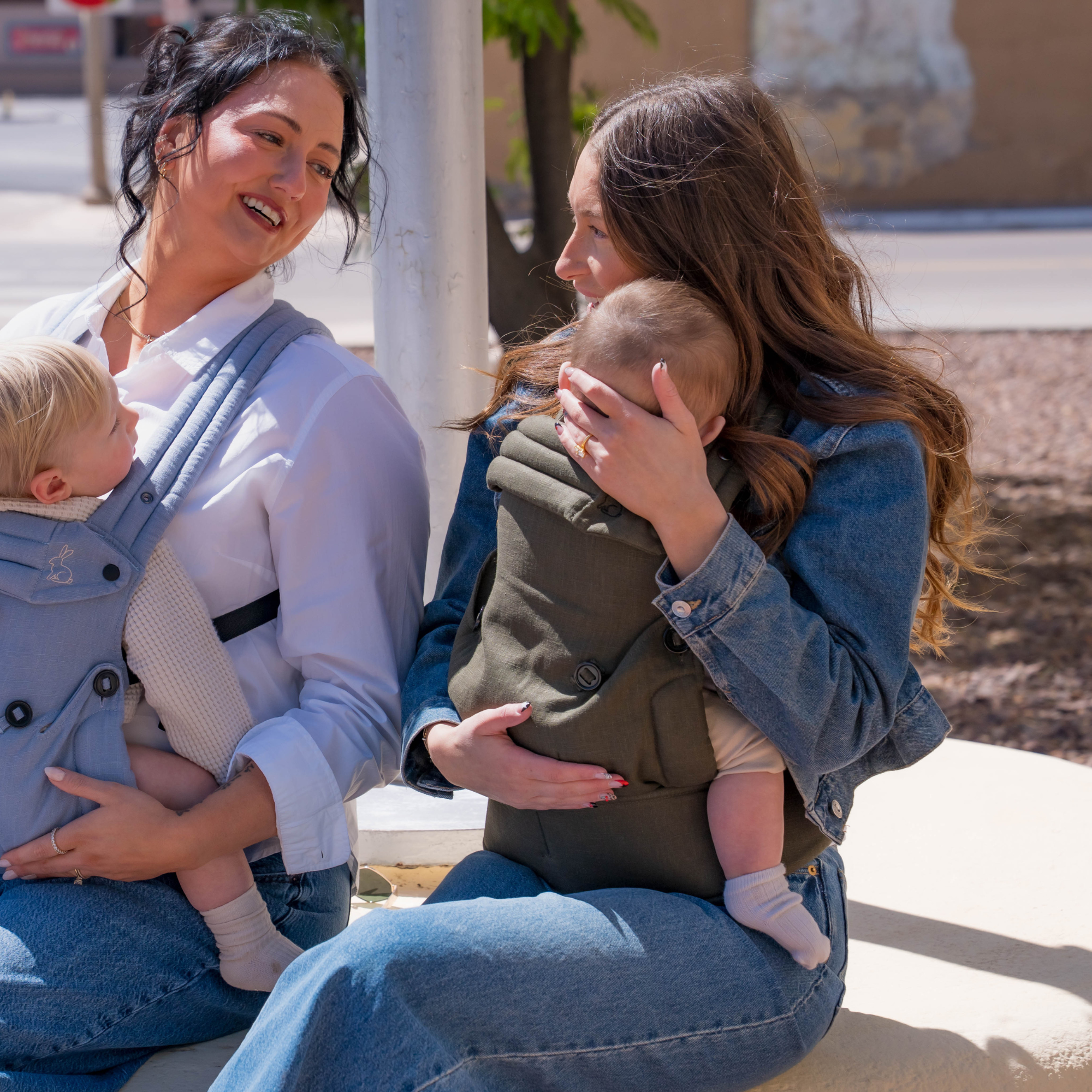 Mom wearing ergonomic olive green baby carrier with baby outdoors