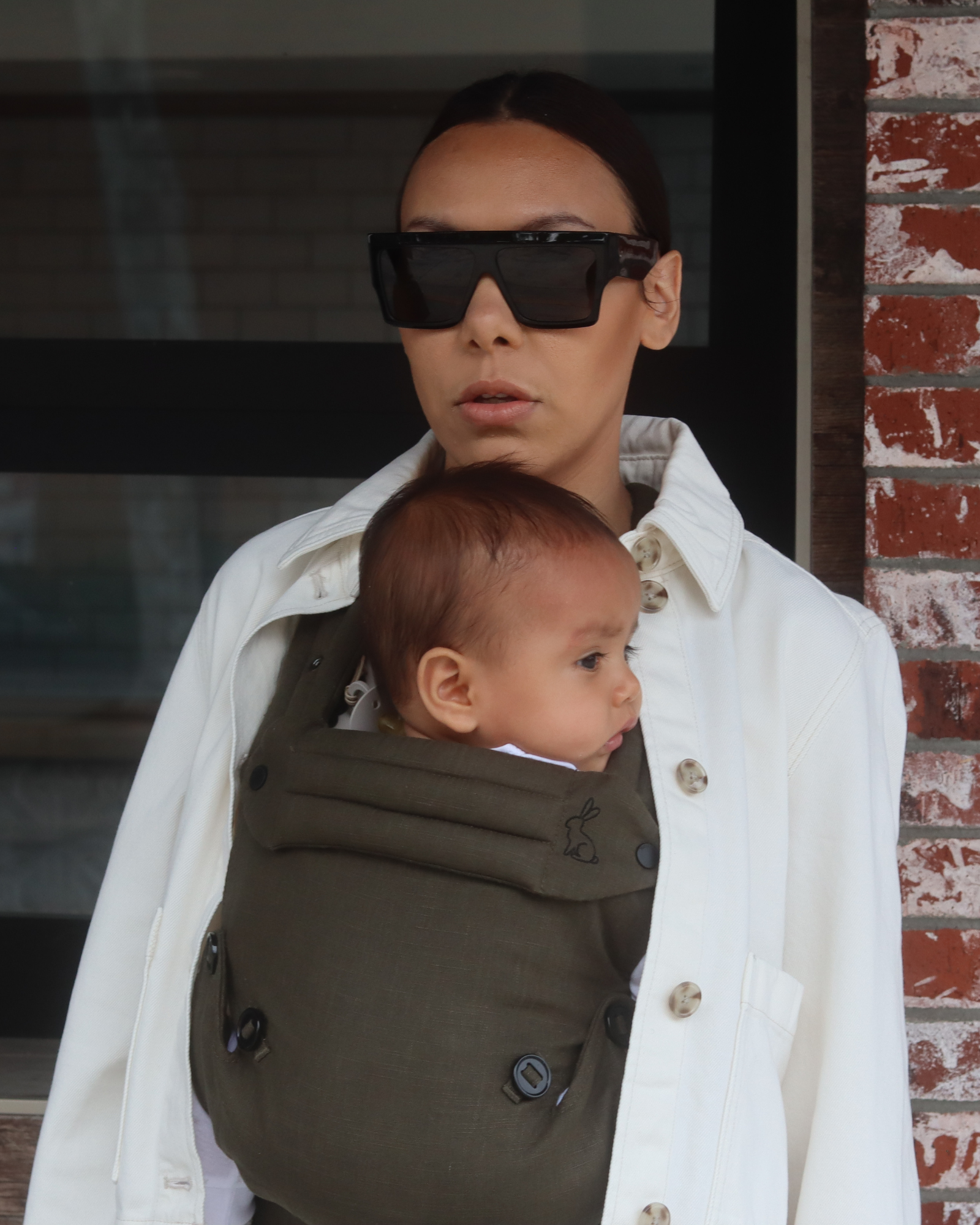 olive green baby carrier with inward-facing carry position