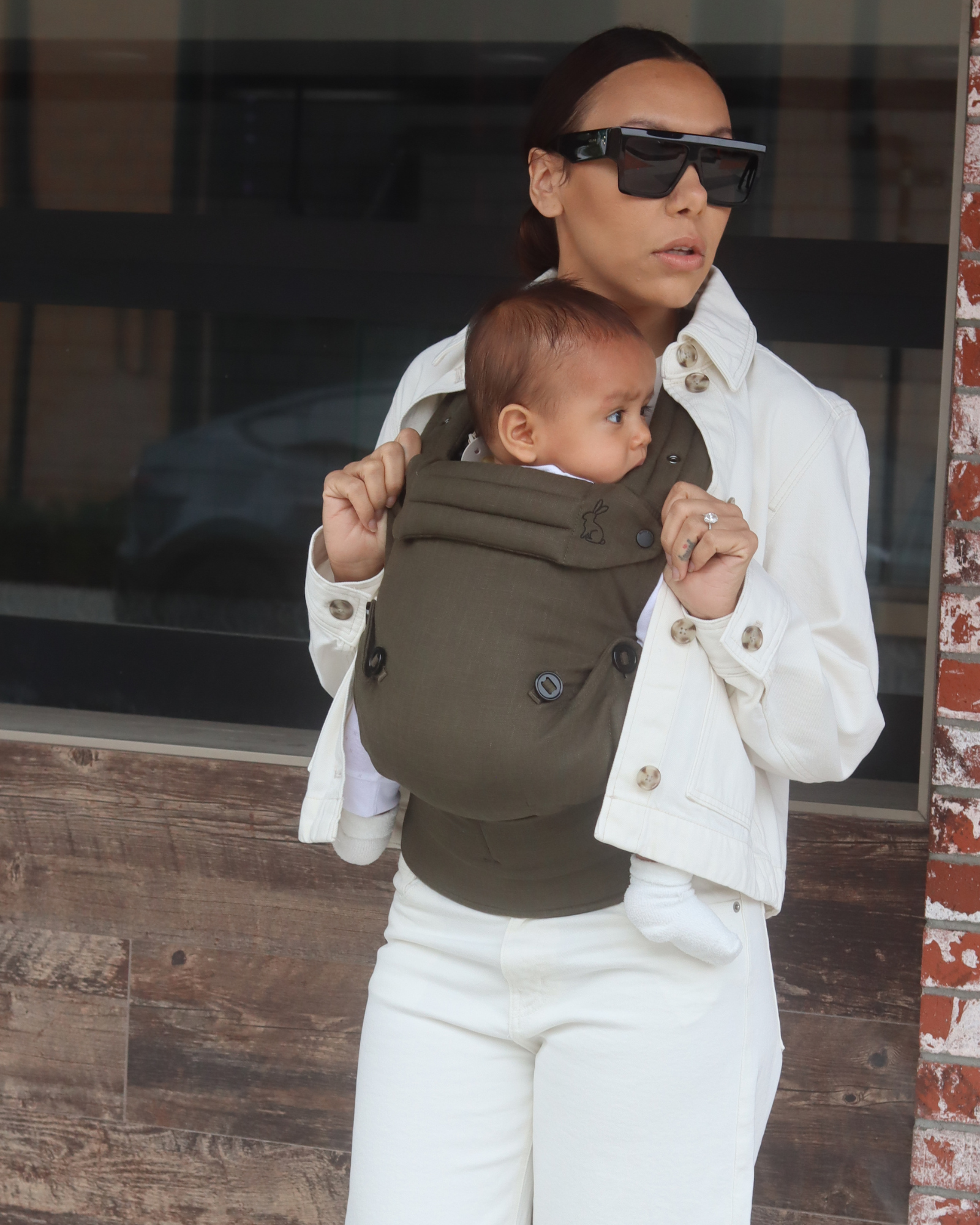 green baby carrier with inward-facing carry position