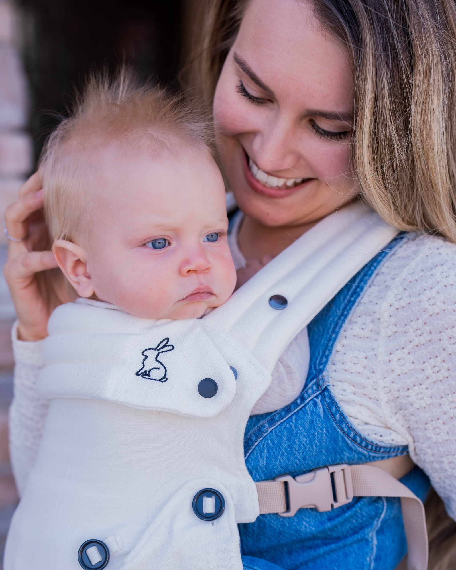 cream baby carrier with inward-facing carry position
