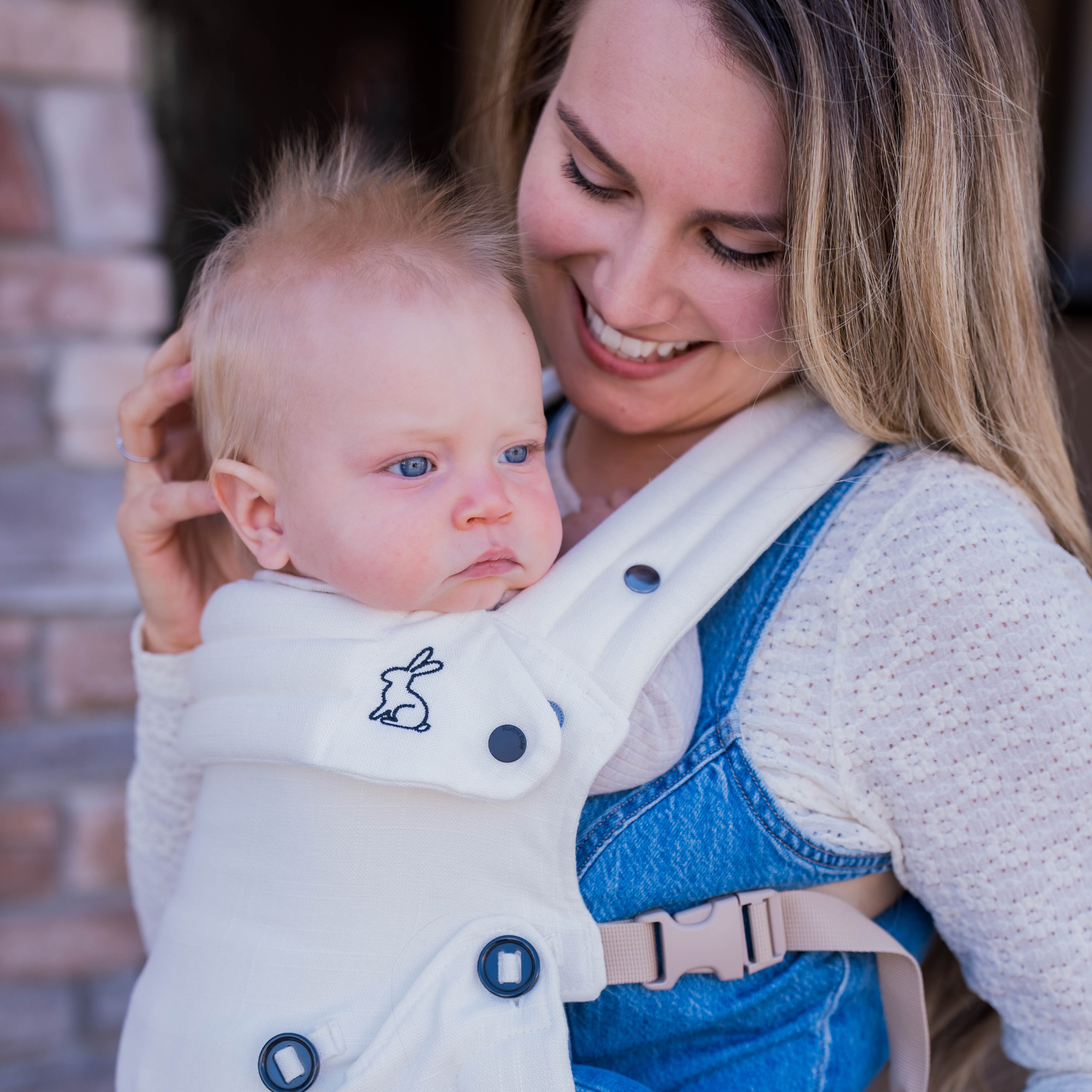 cream baby carrier with inward-facing carry position