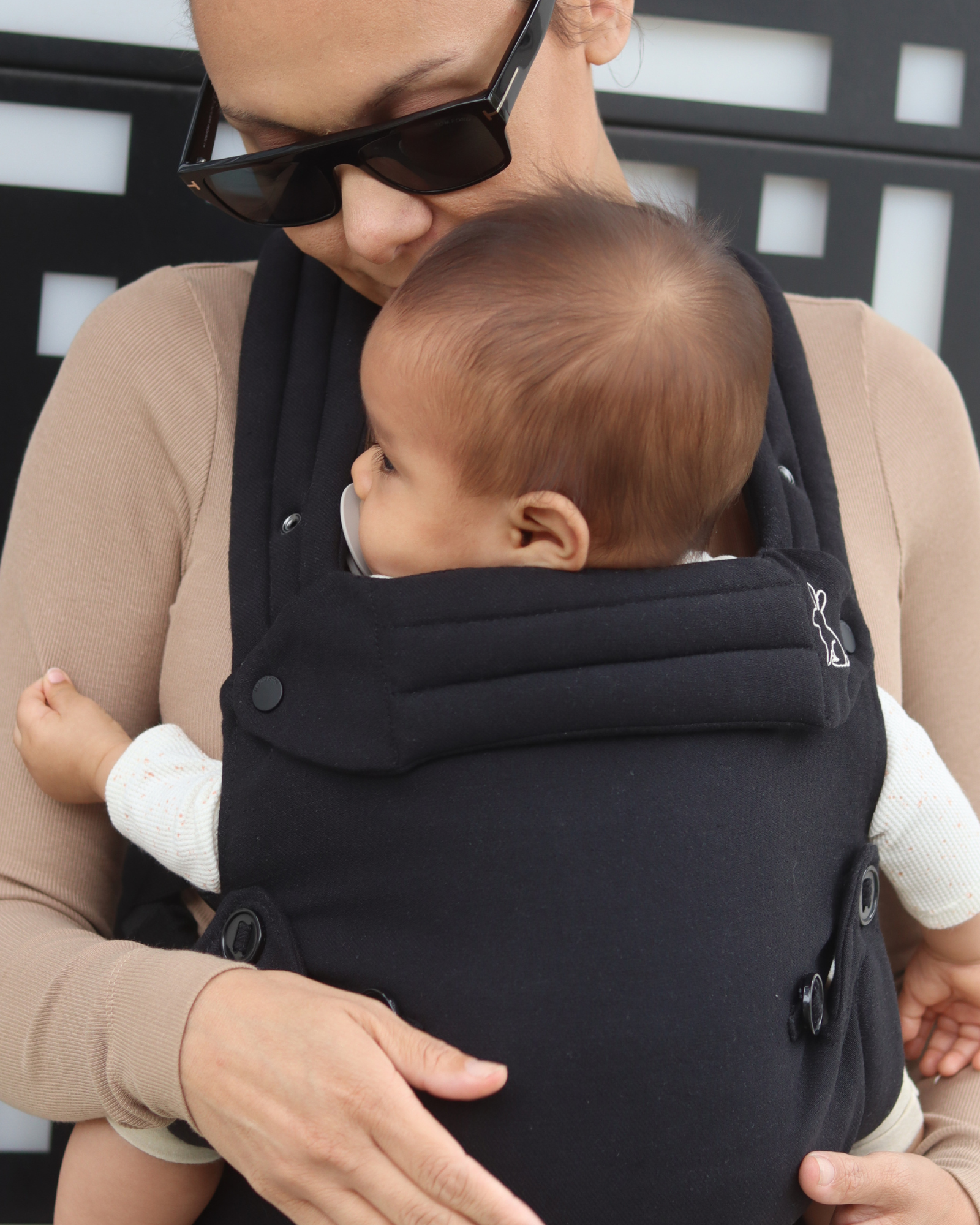 Black baby carrier with inward-facing carry position