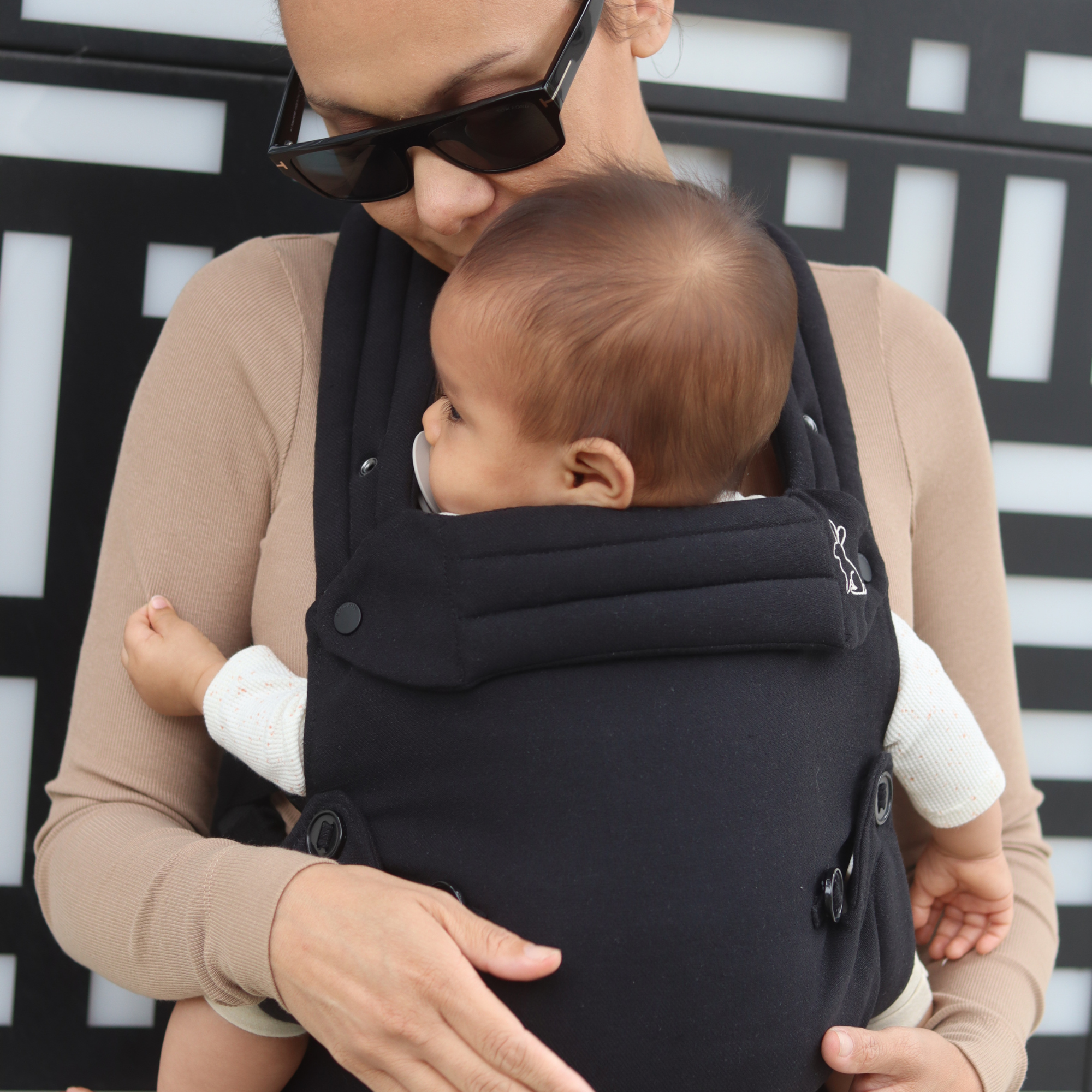 Black baby carrier with inward-facing carry position