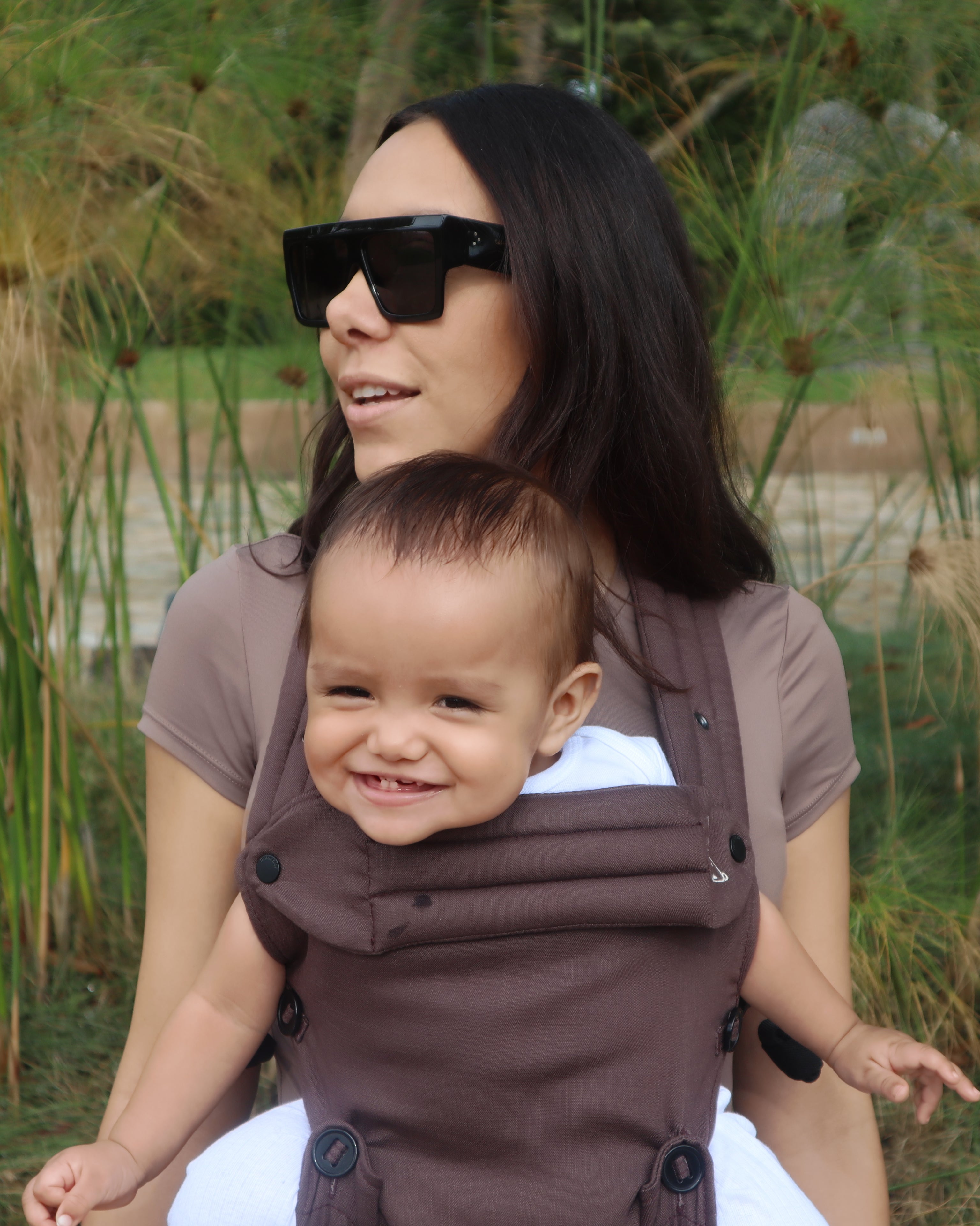 Brown baby carrier with outward-facing carry position