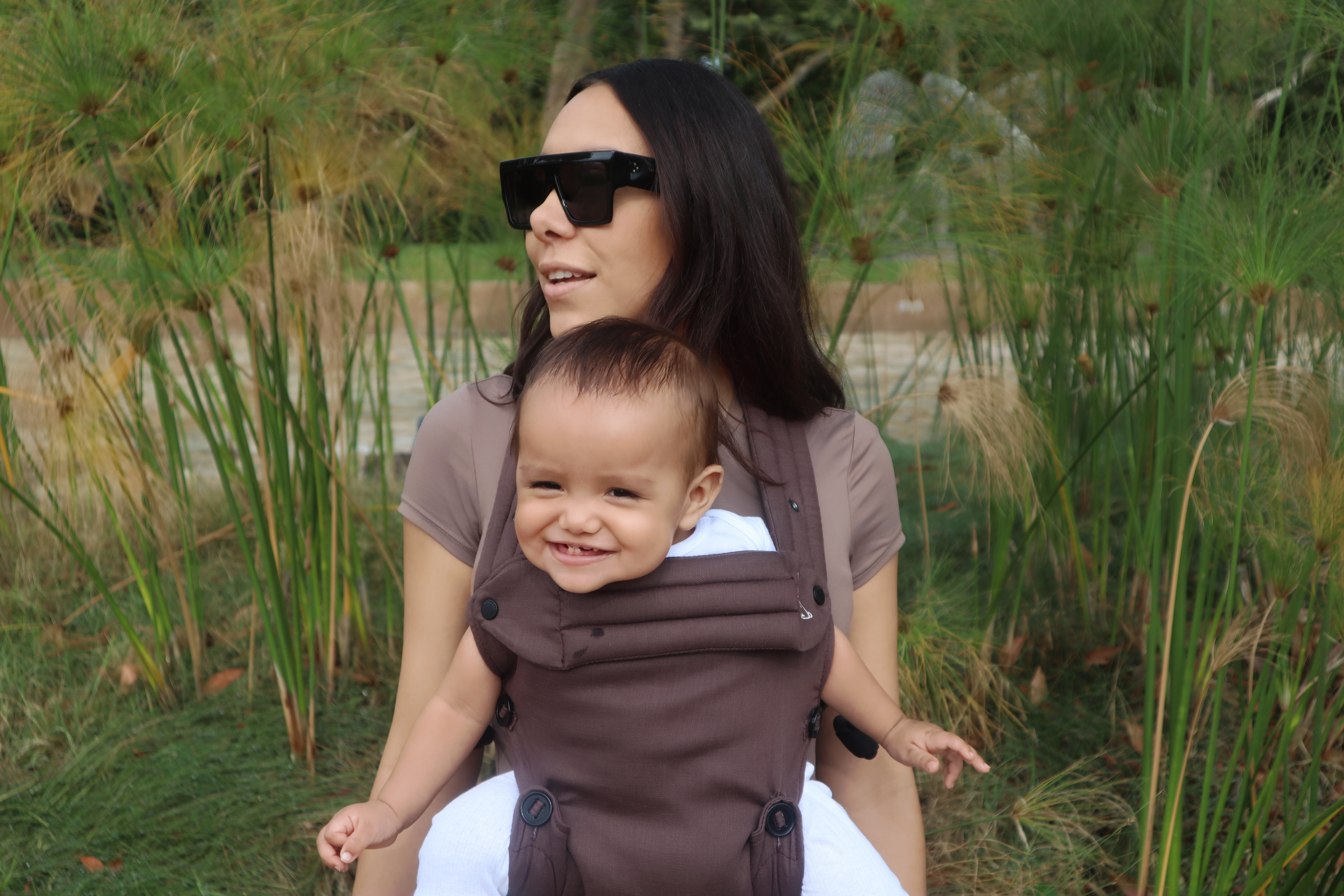 Brown baby carrier with outward-facing carry position