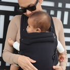 Black baby carrier with inward-facing carry position